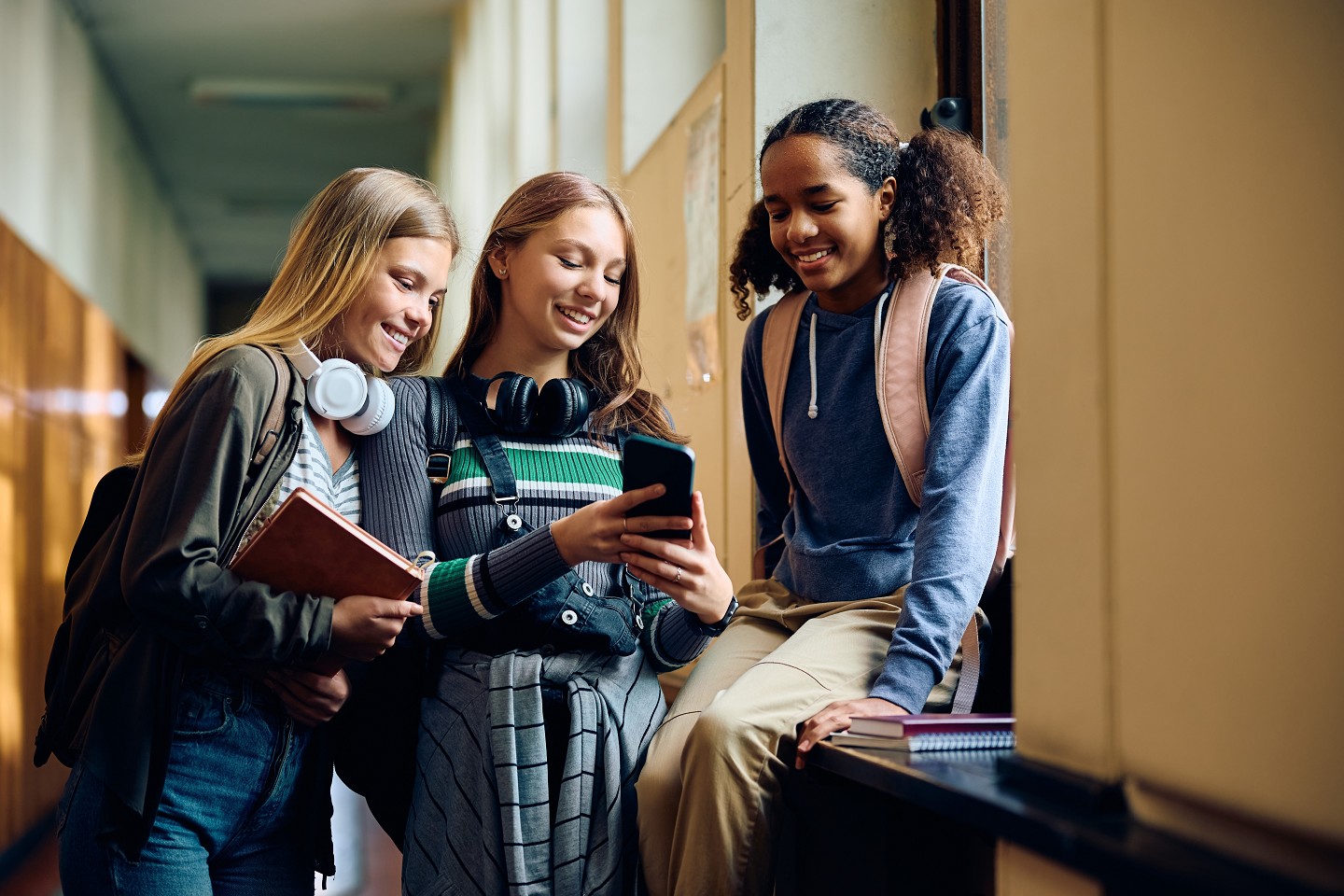 students looking at a cell phone screen. 